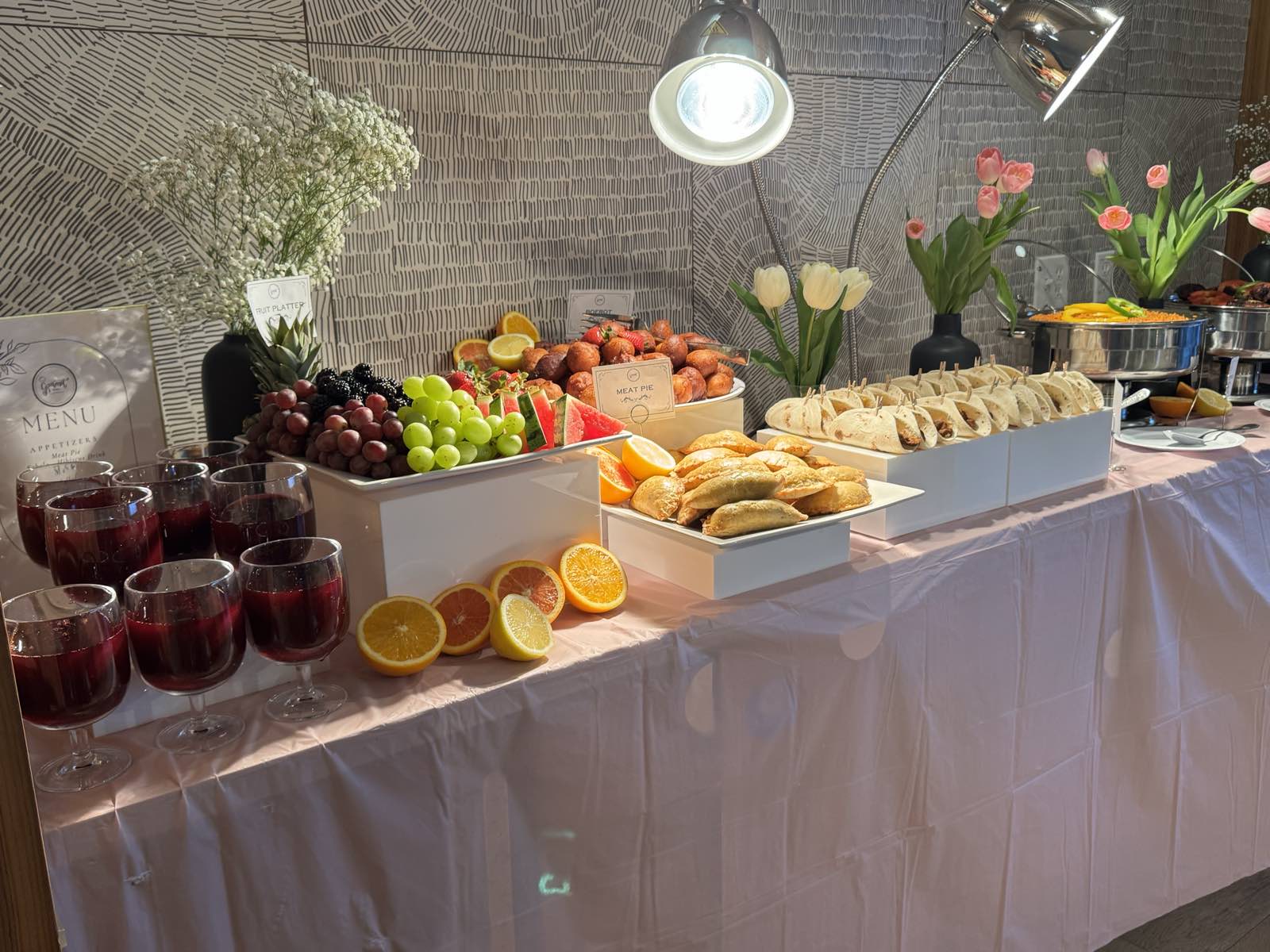 A full GourmetMaria spread of tacos, meat pies, jollof rice, and sobolo at an intimate birthday celebration