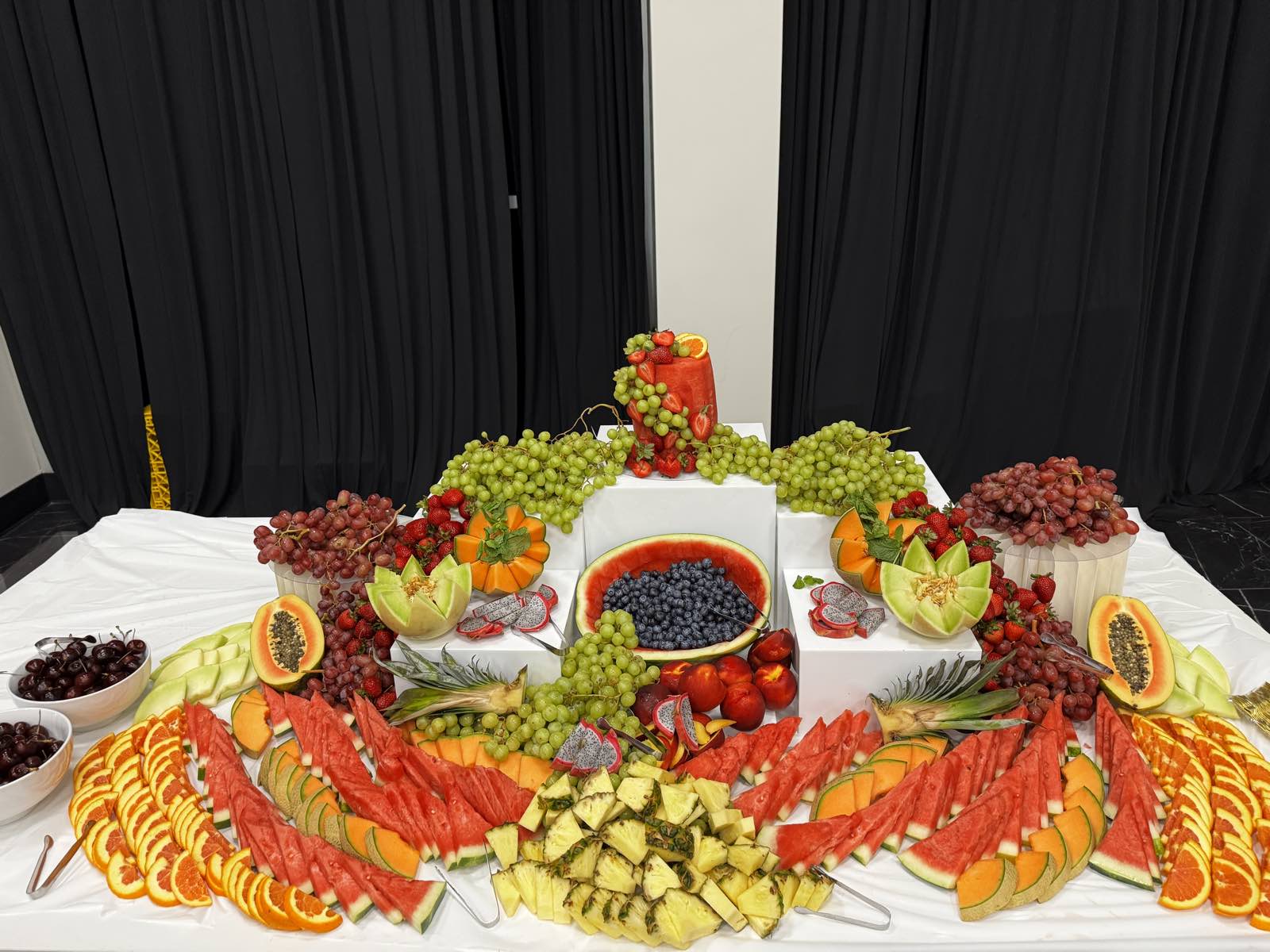 An elaborate tiered fruit display by GourmetMaria, styled for a wedding reception