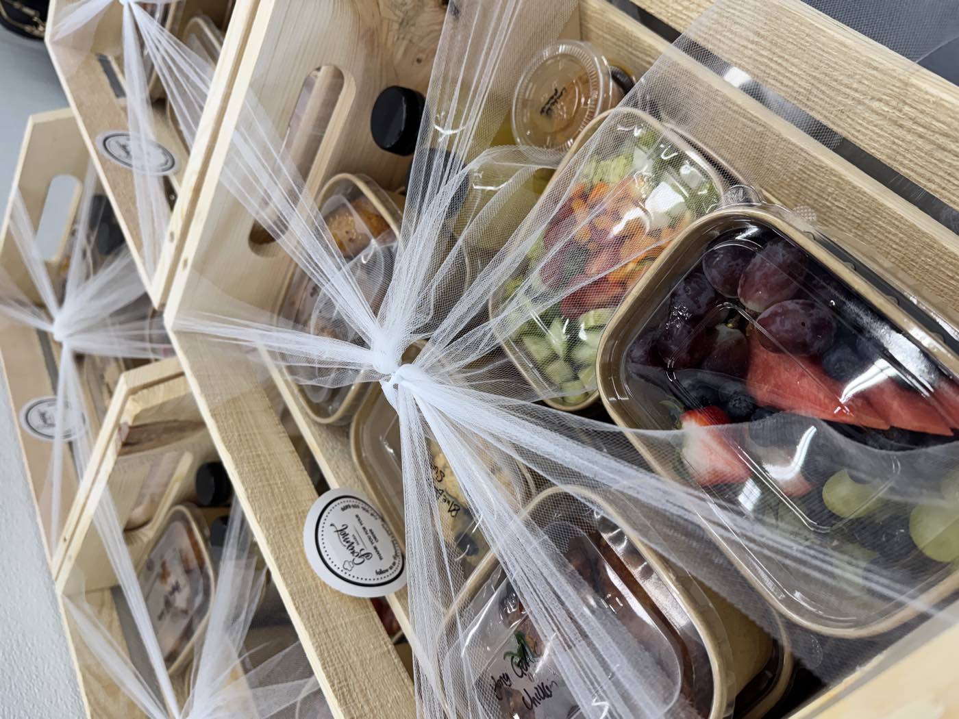 A wooden crate gift basket by GourmetMaria, wrapped and ready for gifting