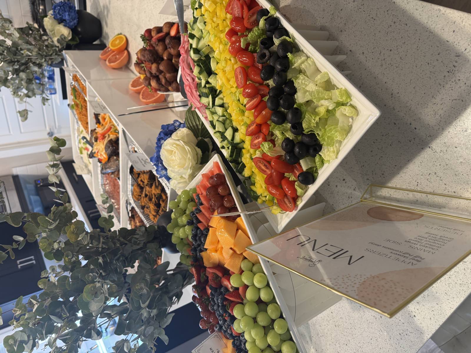 A GourmetMaria spread set up for an in-home private dinner, with a printed menu card