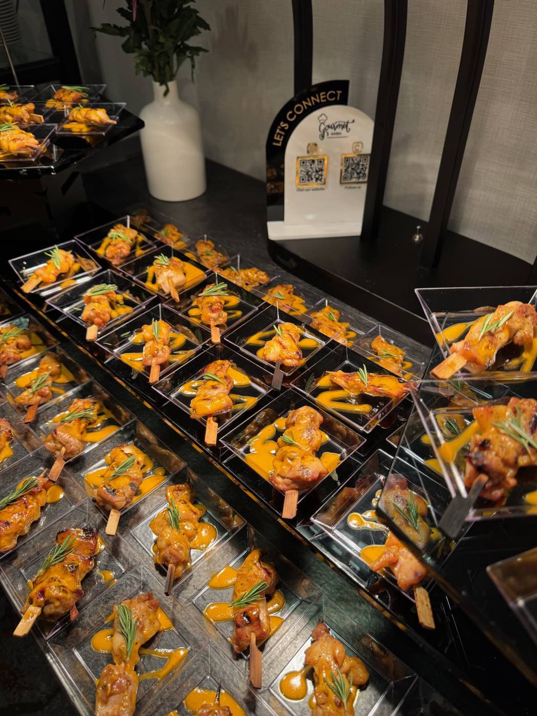 Suya skewers with rosemary garnish, plated for a wedding reception